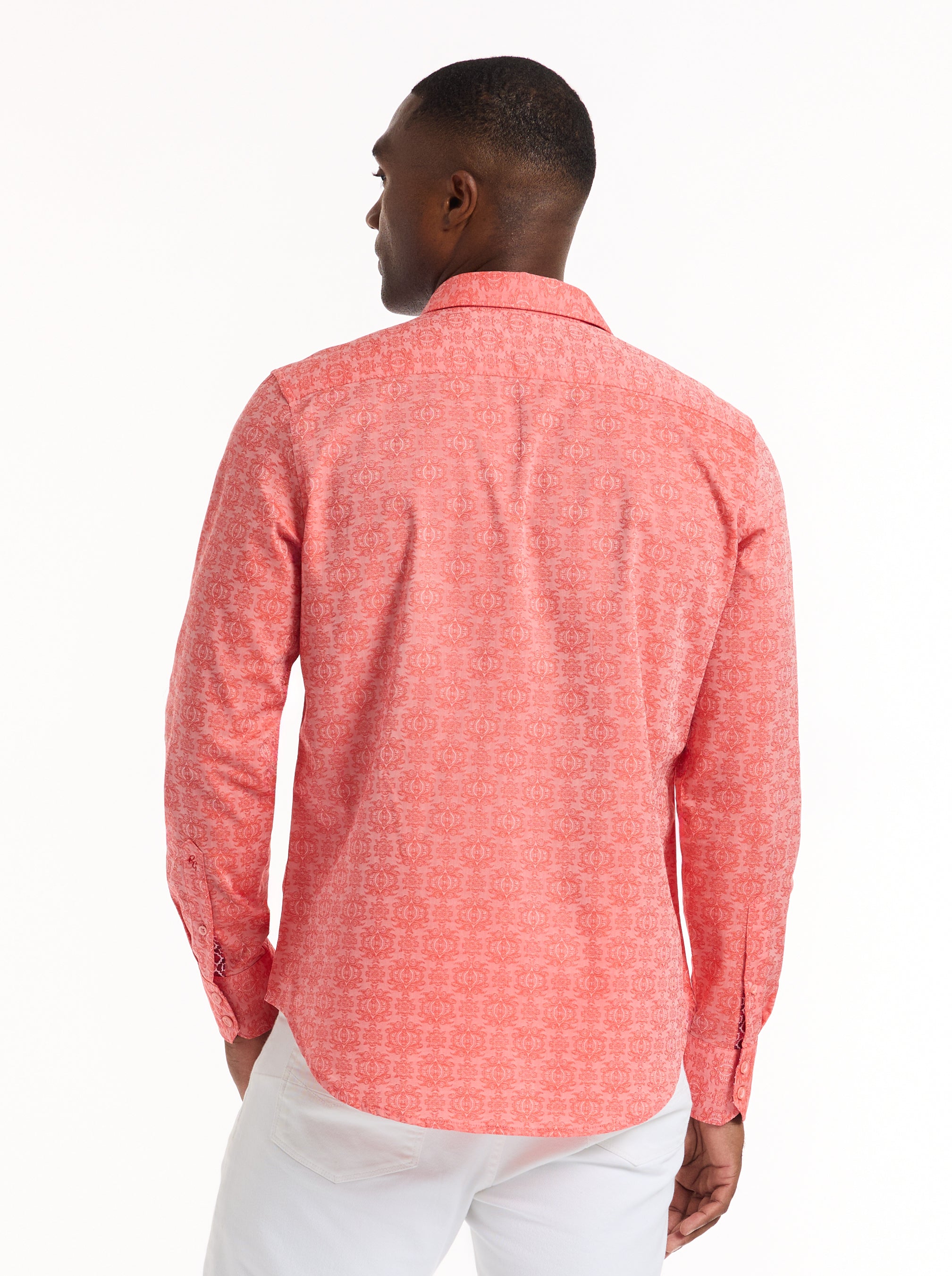 Man wearing a coral patterned shirt on a white background