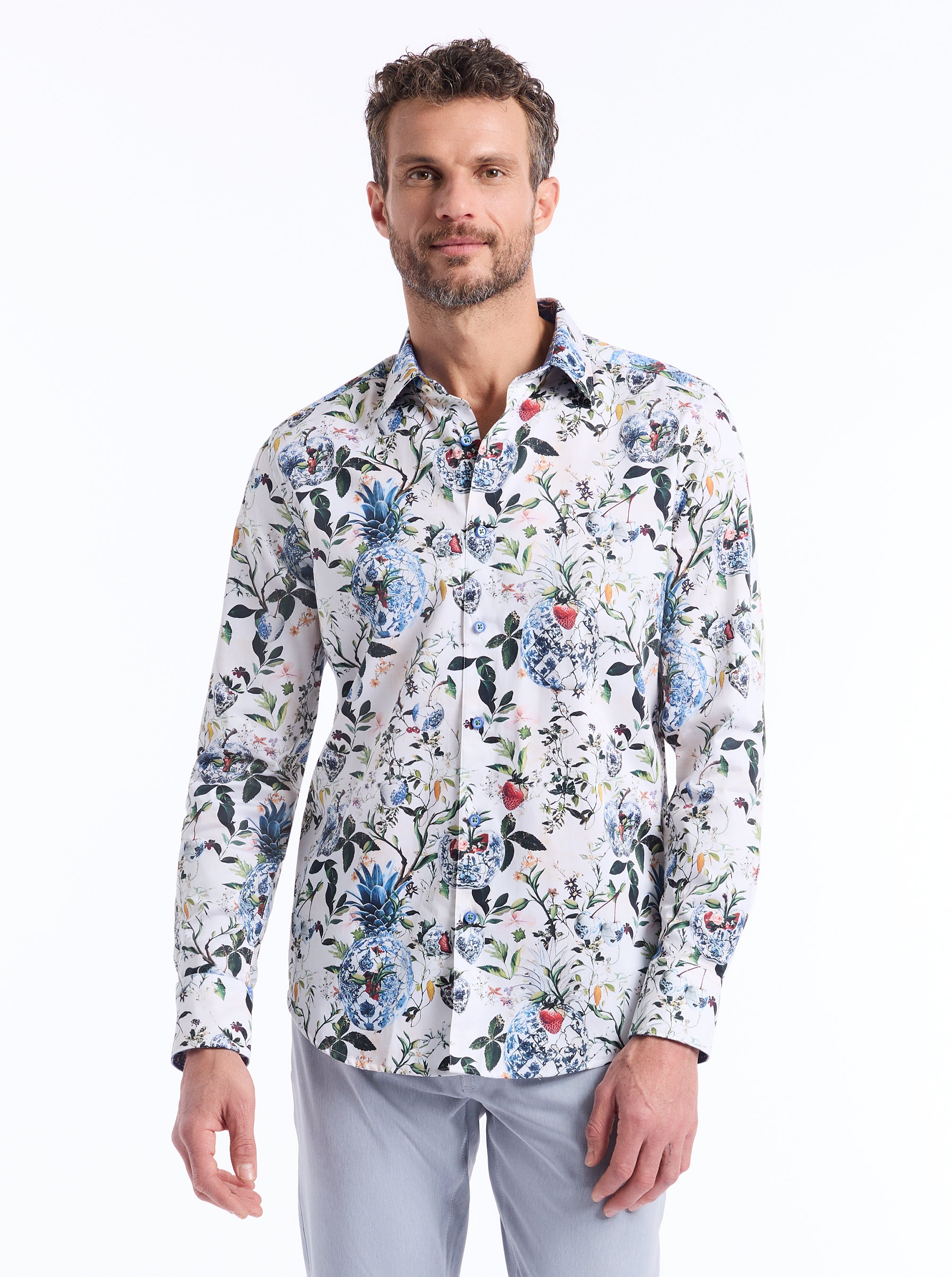 Man wearing a floral patterned shirt on a white background