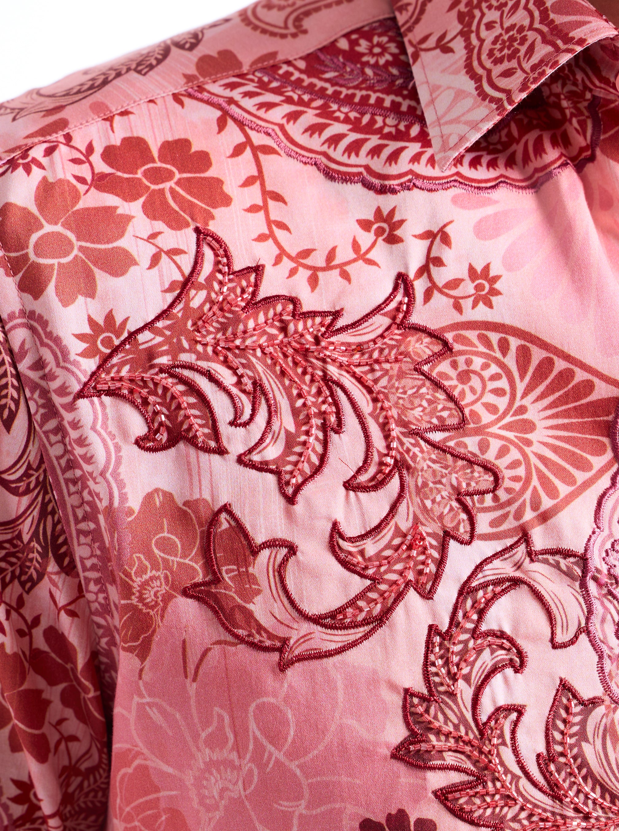 Close-up of a pink shirt with red floral and paisley patterns