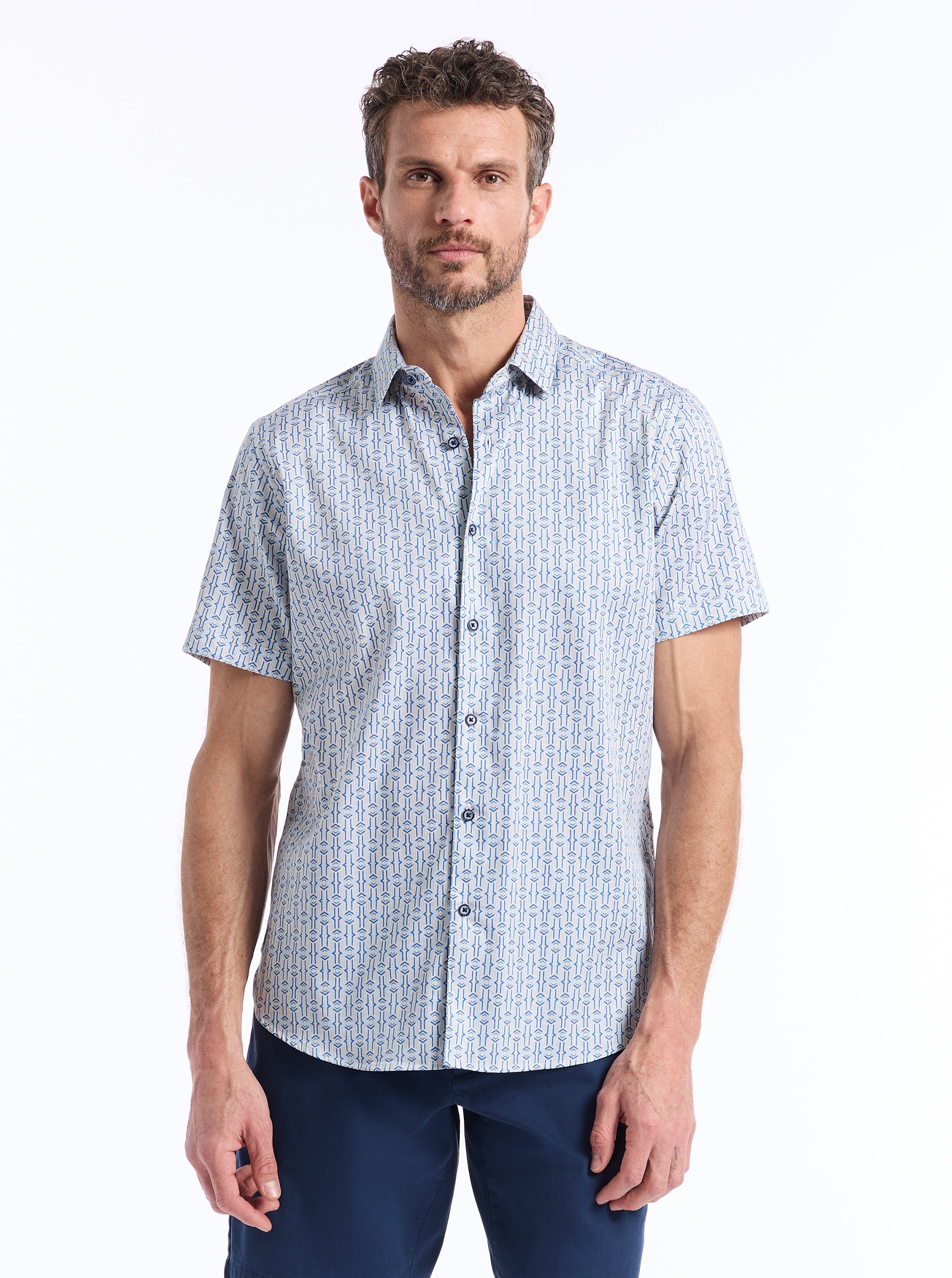 Man wearing a patterned short-sleeve shirt on a white background