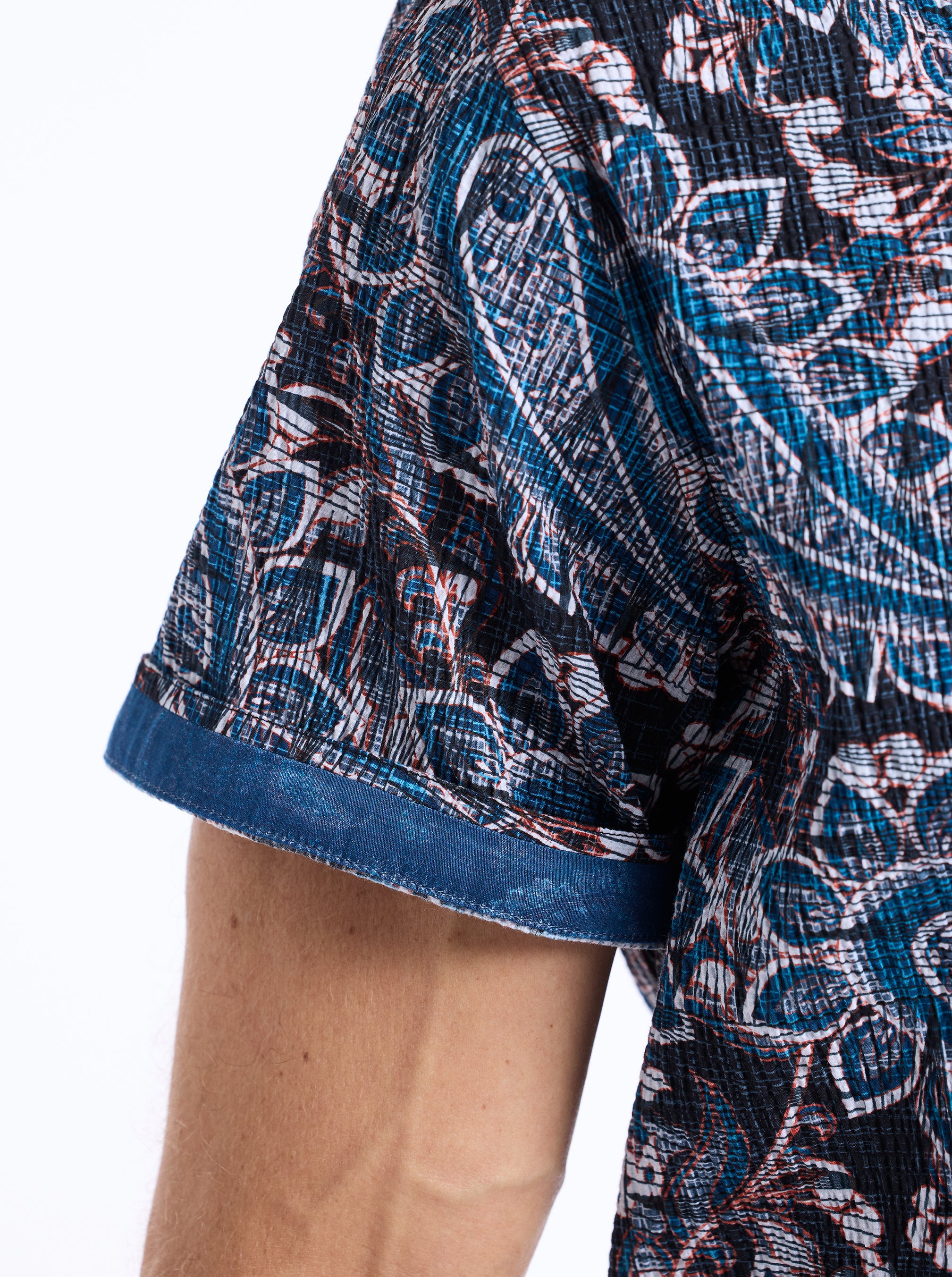 Close-up of a person wearing a patterned shirt with a white background