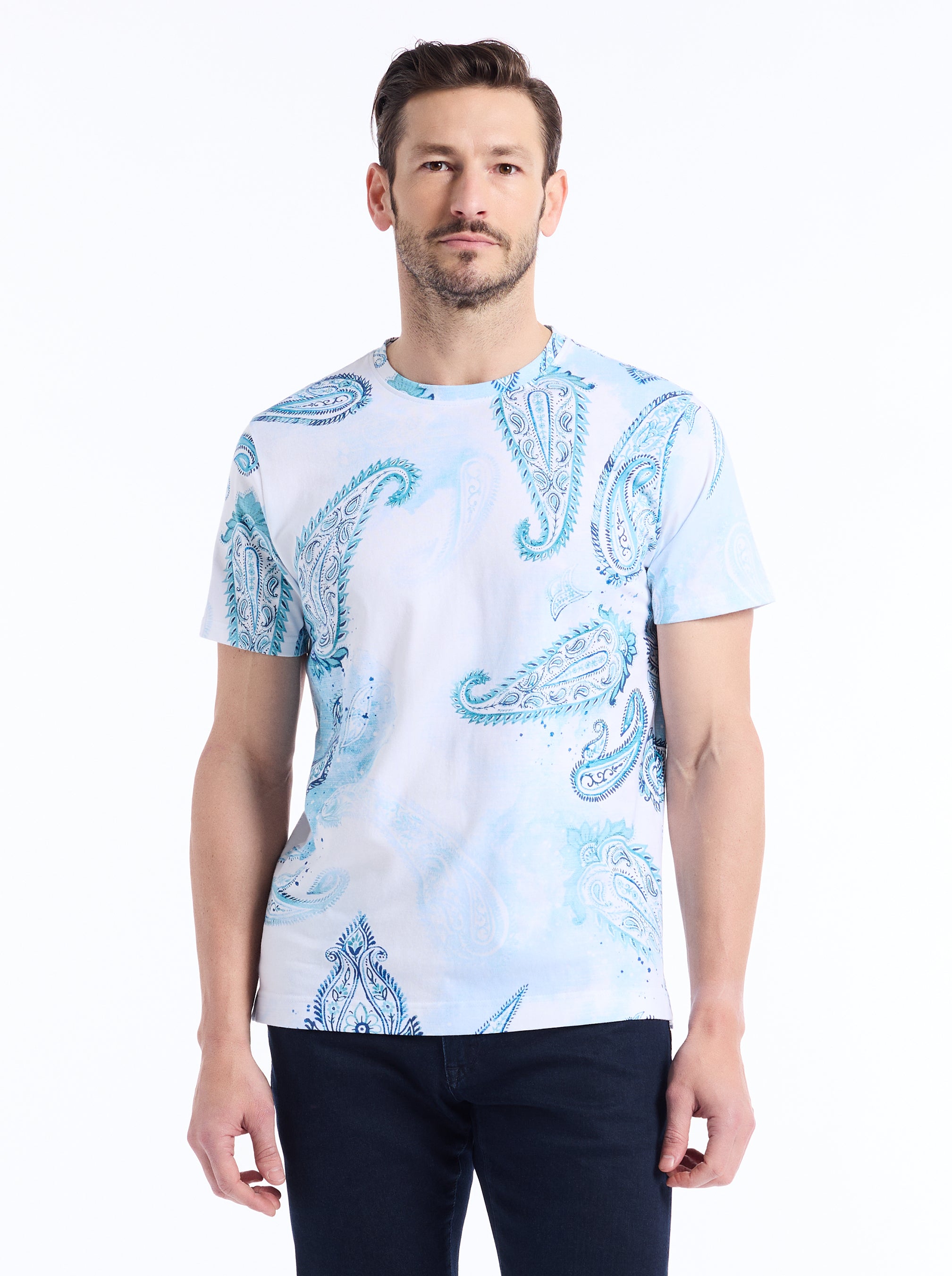 Man wearing a light blue t-shirt with paisley pattern on a white background