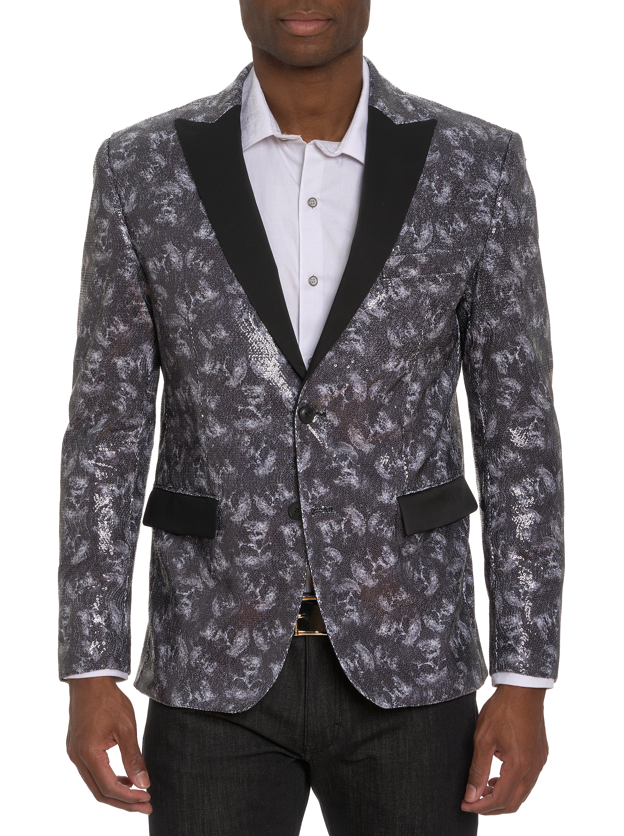 A man wearing a black and silver sequin blazer with contrasting lapels and pocket flaps, featuring an allover skull print.