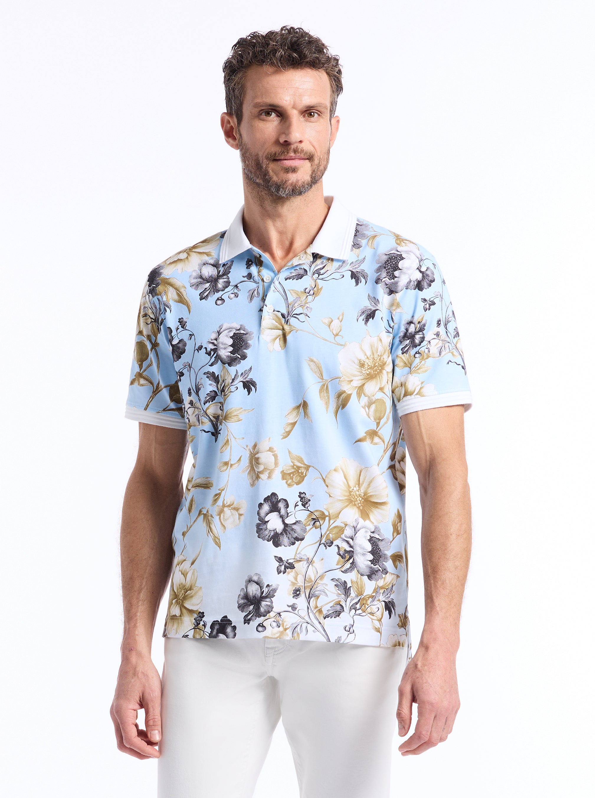Man wearing a light blue and gold/tan floral-patterned shirt on a white background