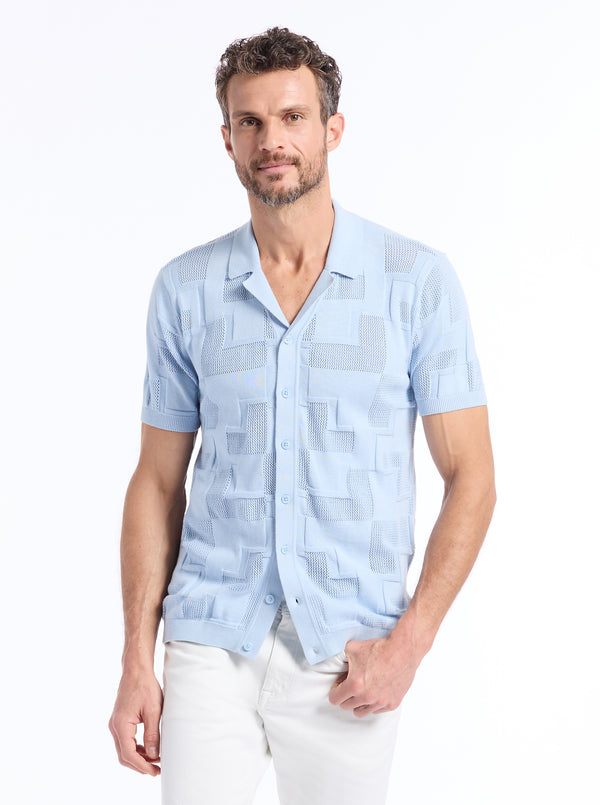 Man wearing a light blue patterned short-sleeve knit shirt on a white background