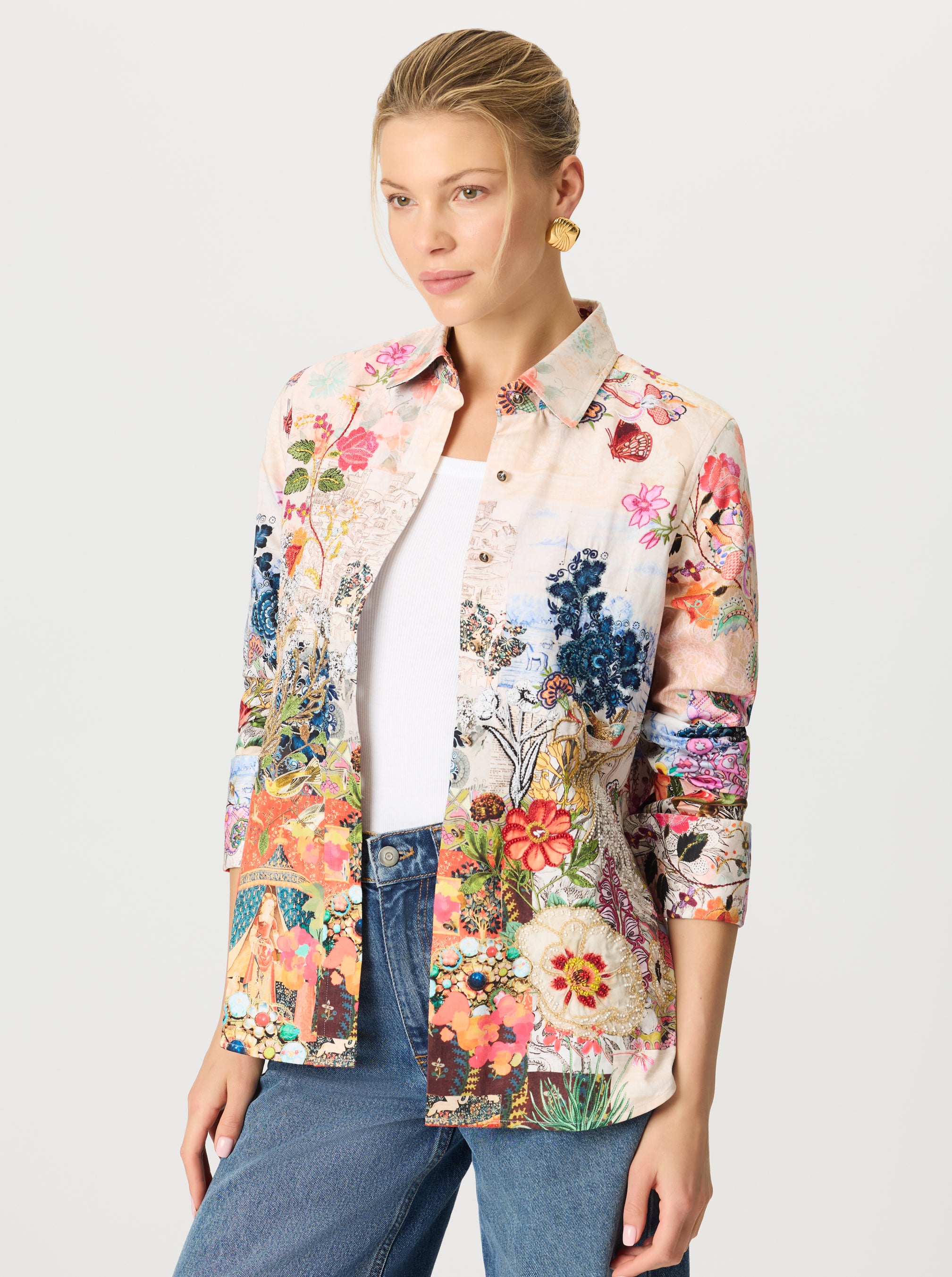 Woman wearing a colorful floral shirt on a plain background