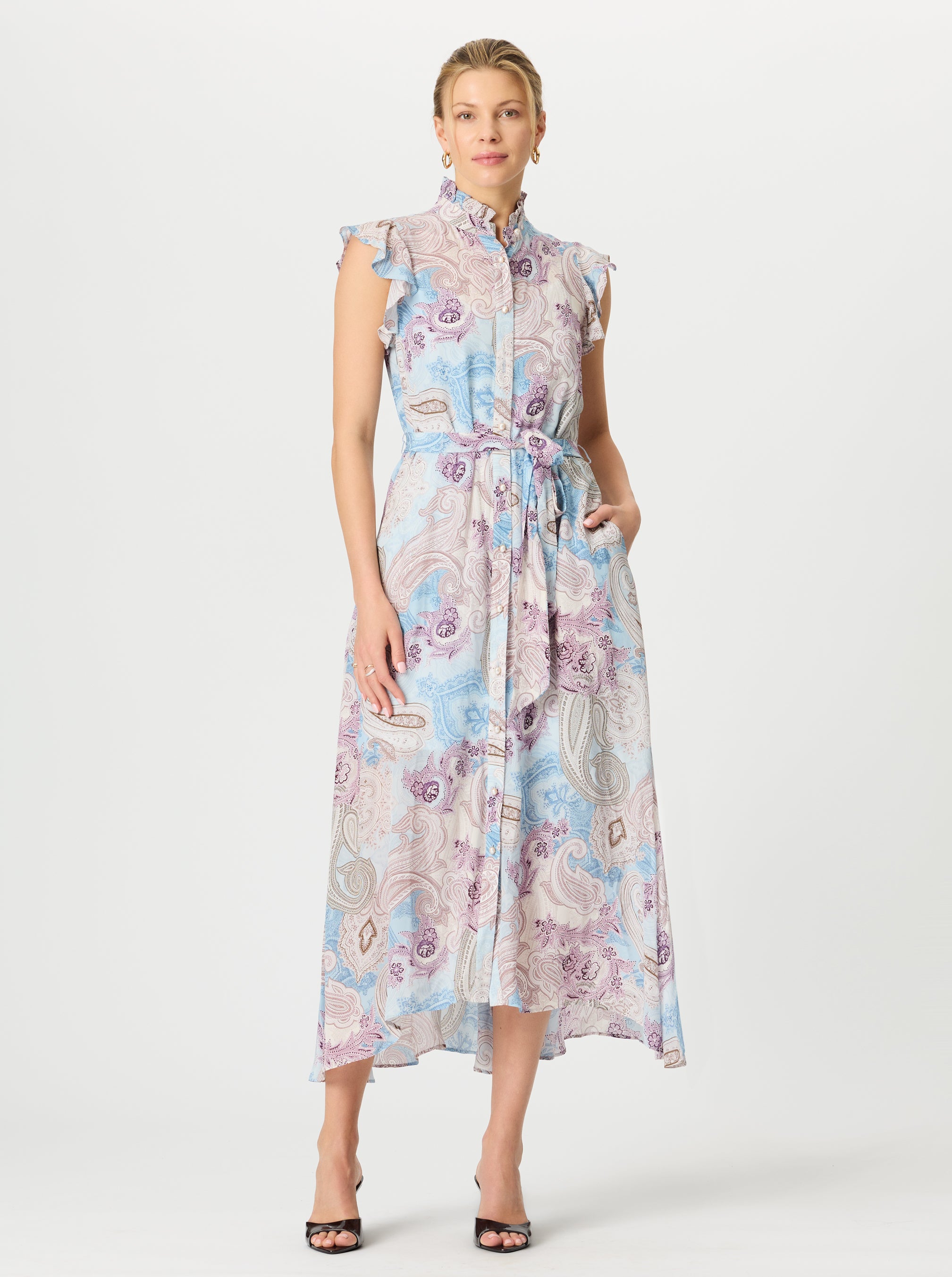 Woman wearing a paisley patterned dress on a white background