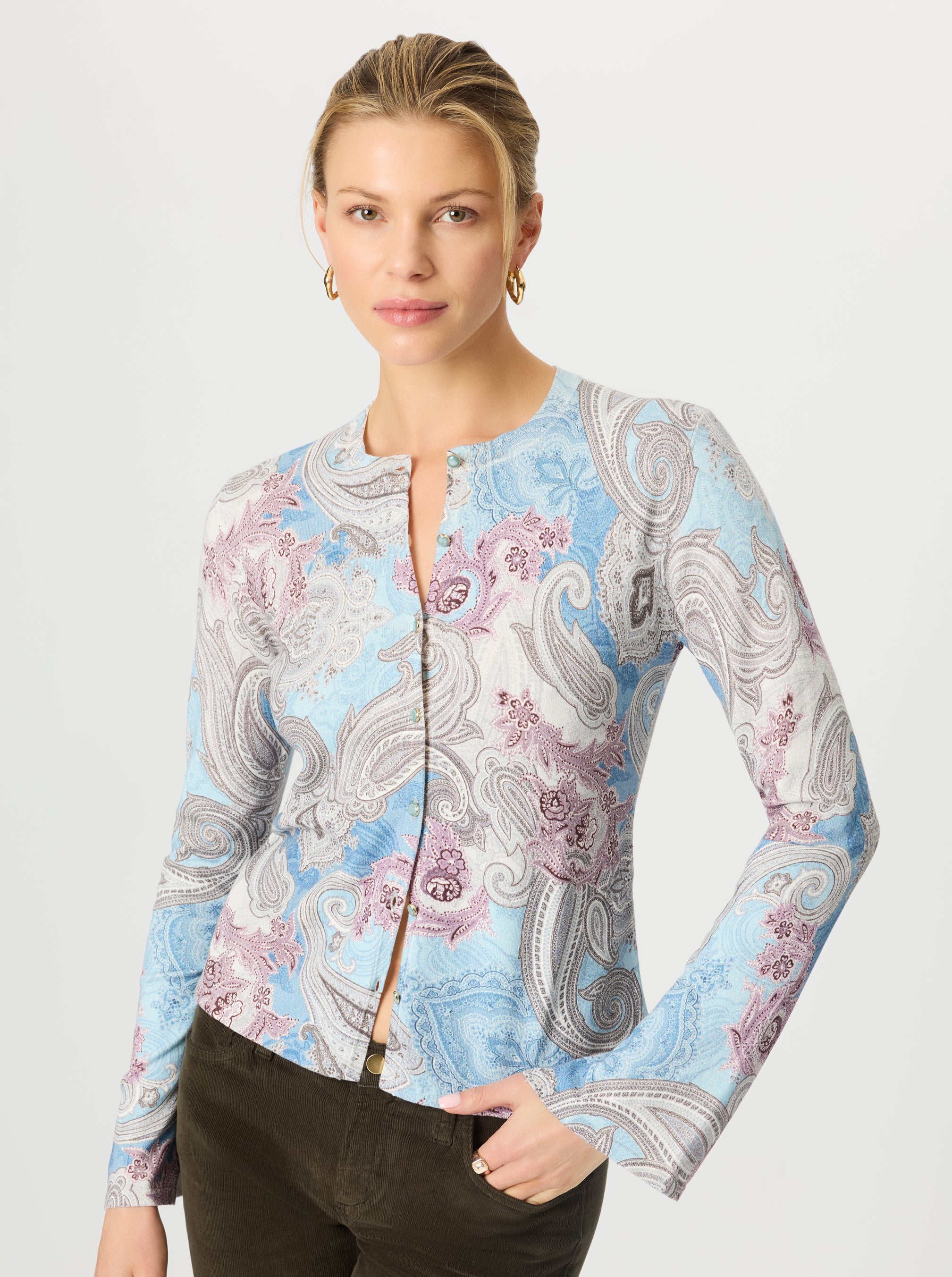 Woman wearing a paisley patterned long-sleeve top on a white background