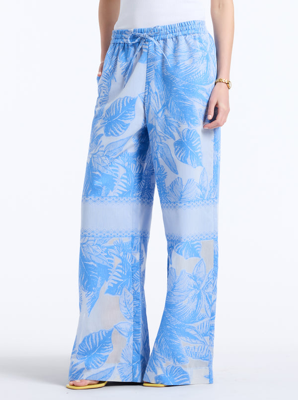 Blue and white leaf-patterned pants on a white background