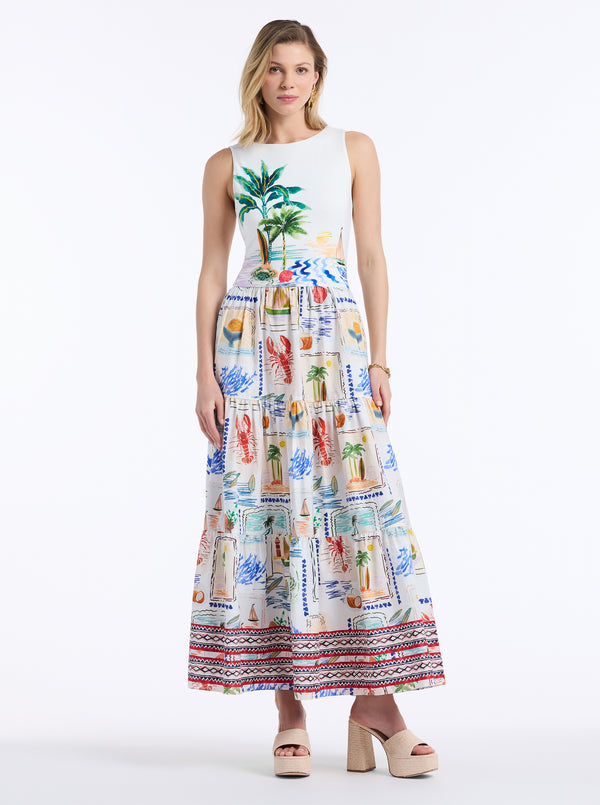 Woman wearing a sleeveless dress with a colorful tropical pattern on a white background