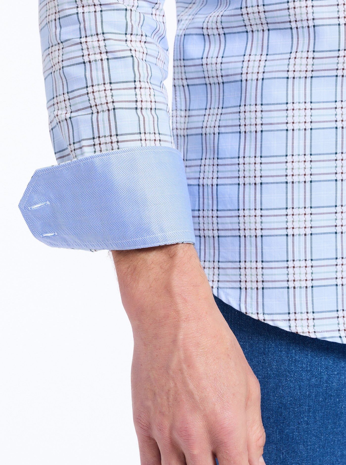 Close-up of a person wearing a blue checkered shirt with rolled-up sleeve.