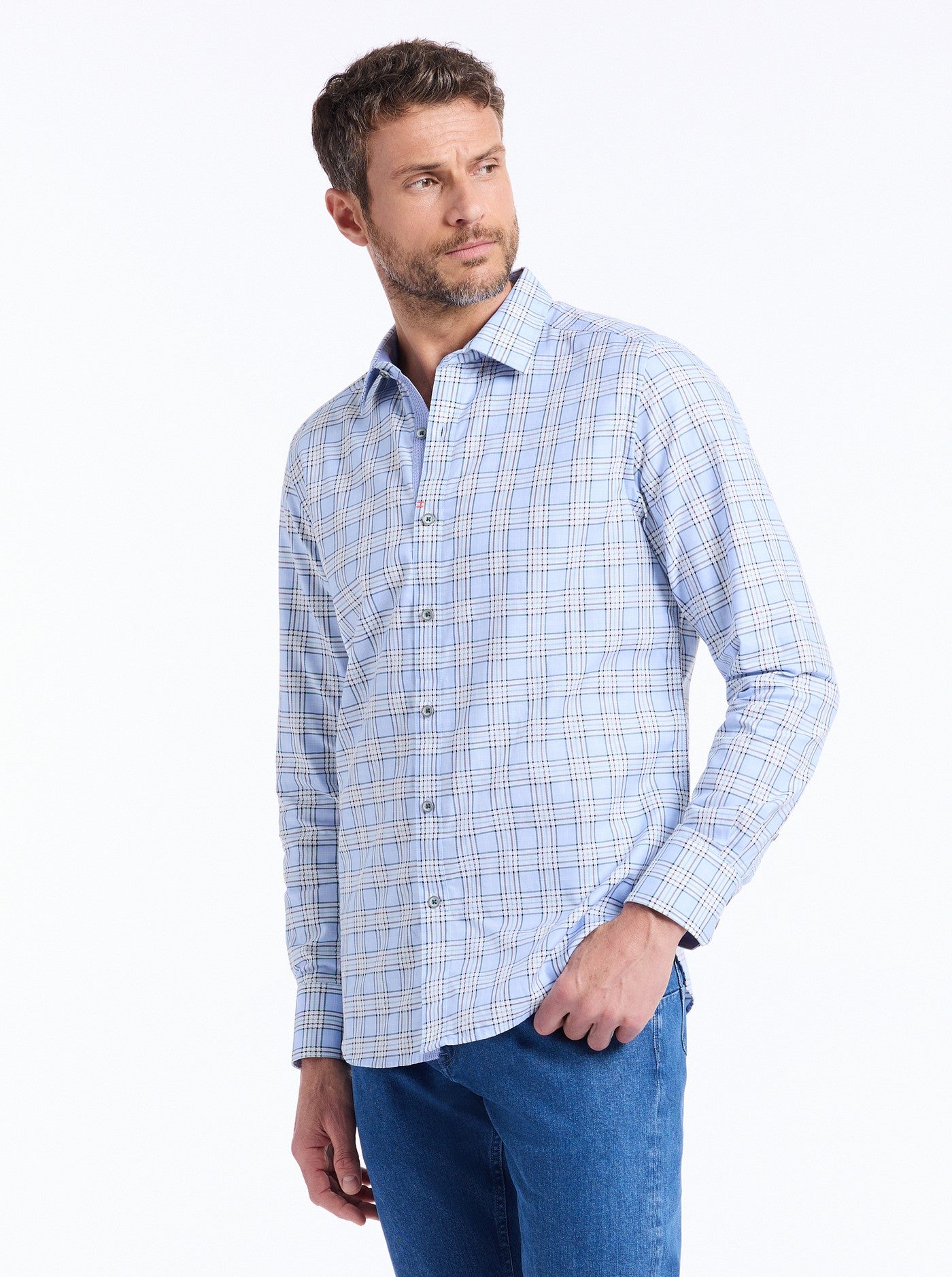 Man wearing a blue checkered shirt and blue jeans on a white background